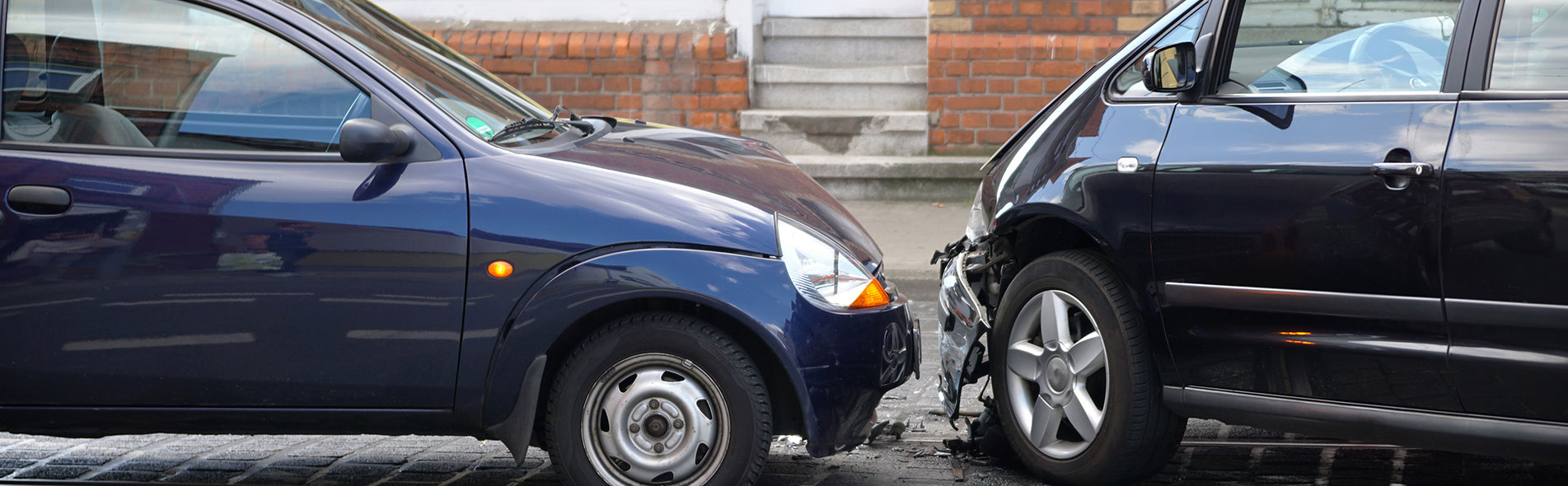 Two cars crashed in a head-on collision with dented hoods