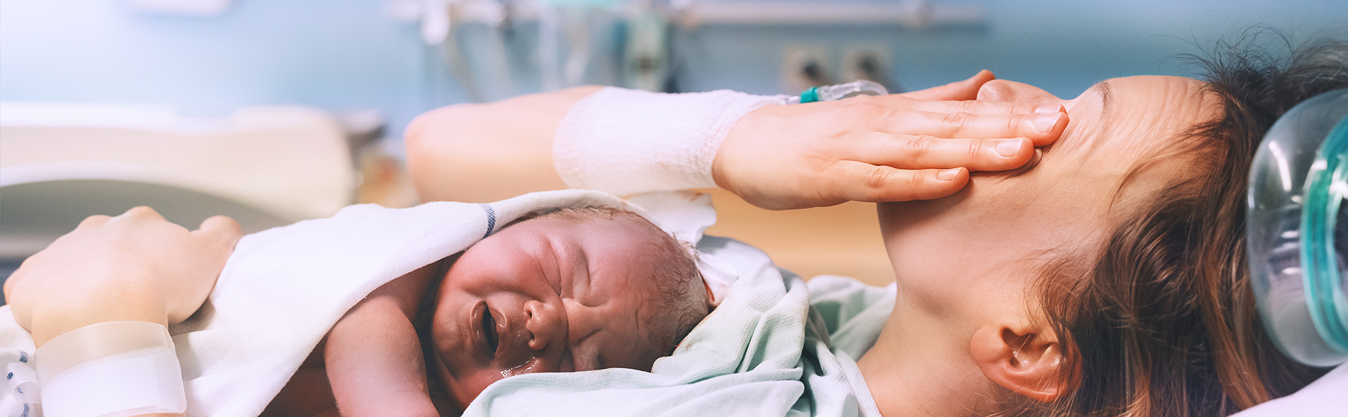 Mother lying on hospital bed crying after her child suffered a birth injury