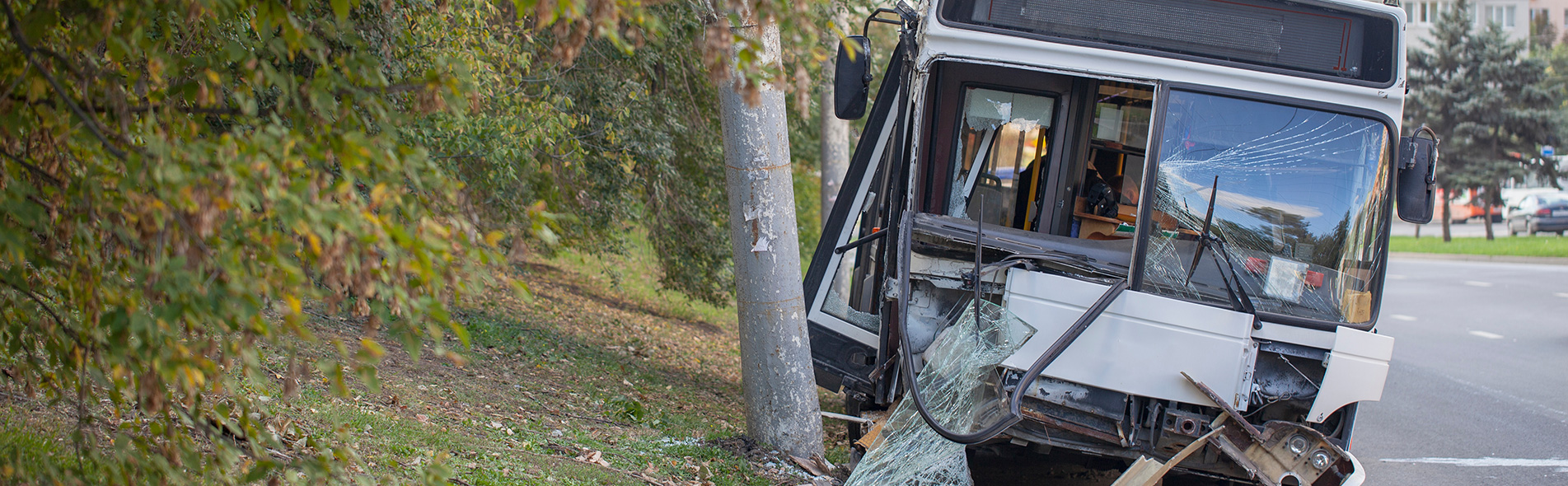 A bus crashed into a sidewalk with shattered mirrors