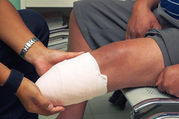 The doctor teaches the patient to take care limb after amputation by bandaging on stump. Process with Vintage tone.