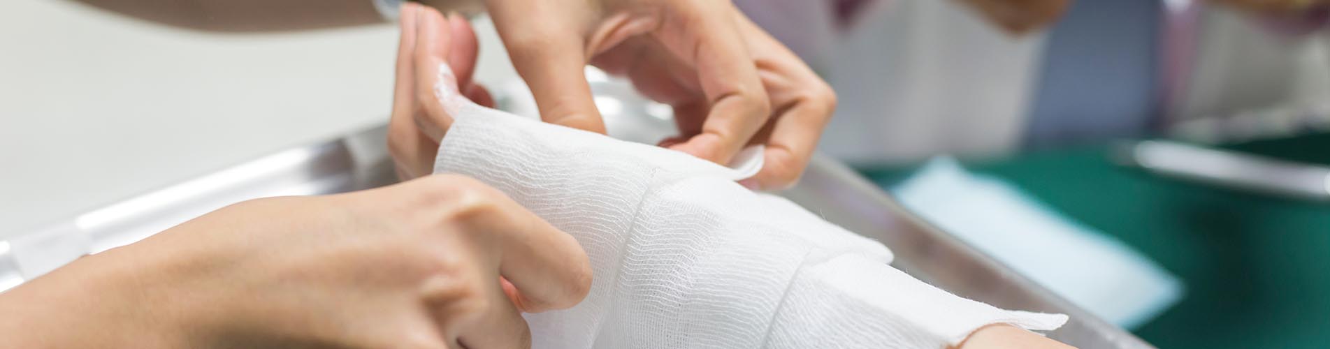 A doctor applies wrapping to a patient’s arm following a burn injury