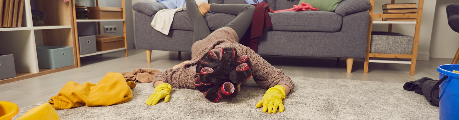 Extremely tired housewife fallen face down on floor while cleaning her messy apartment