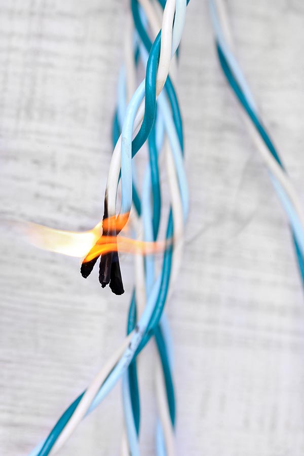 Short circuit, burnt cable, on color wooden background