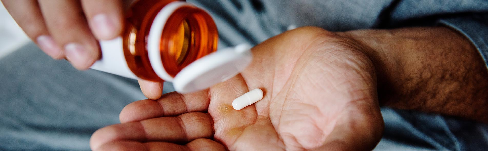 A pill sitting in the hand of a person who is about to be the victim of a medication error