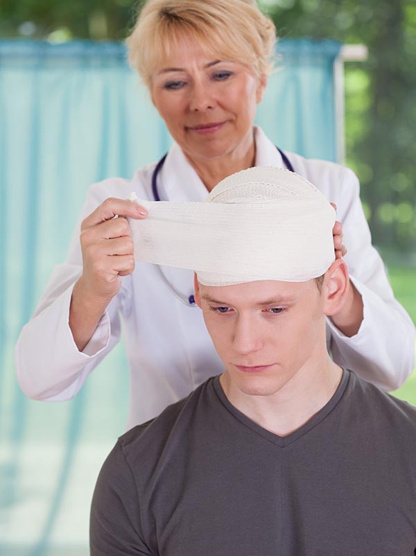 Female physician parcels patient's head at consulting room